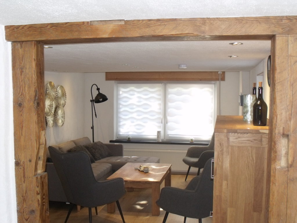 Auszeit Ferienhaus Wohnzimmer mit Balken zum Esszimmer